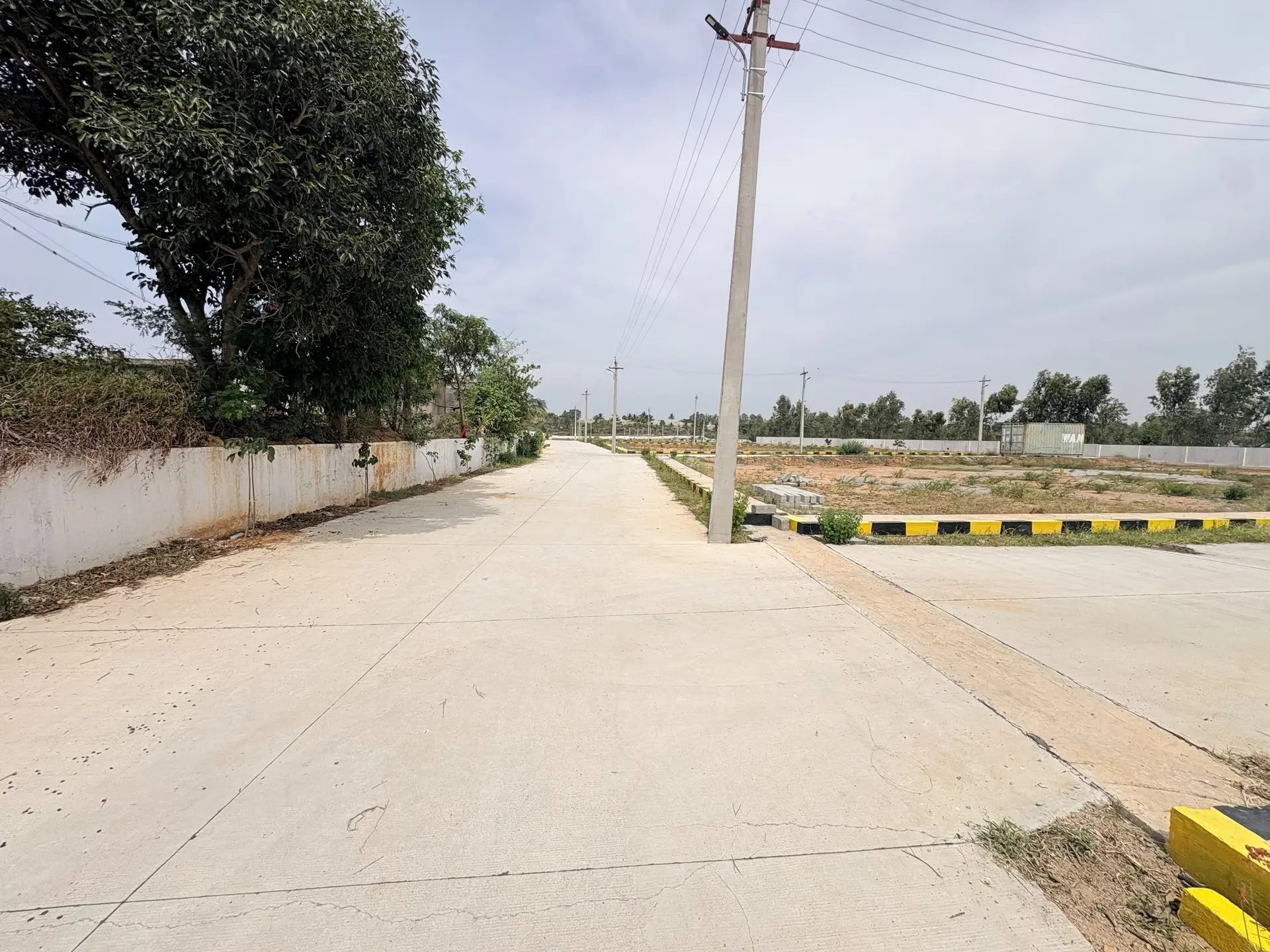 Two concrete roads meeting inside the layout, with painted kerb stones, storm-water kerbing and marked plots on either side.